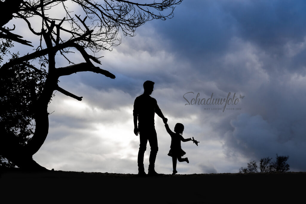 Schaduwfoto Silhouet door Dasja Dijkstra Schaduw van een overleden meisje eindelijk compleet hand in hand met overleden kindje